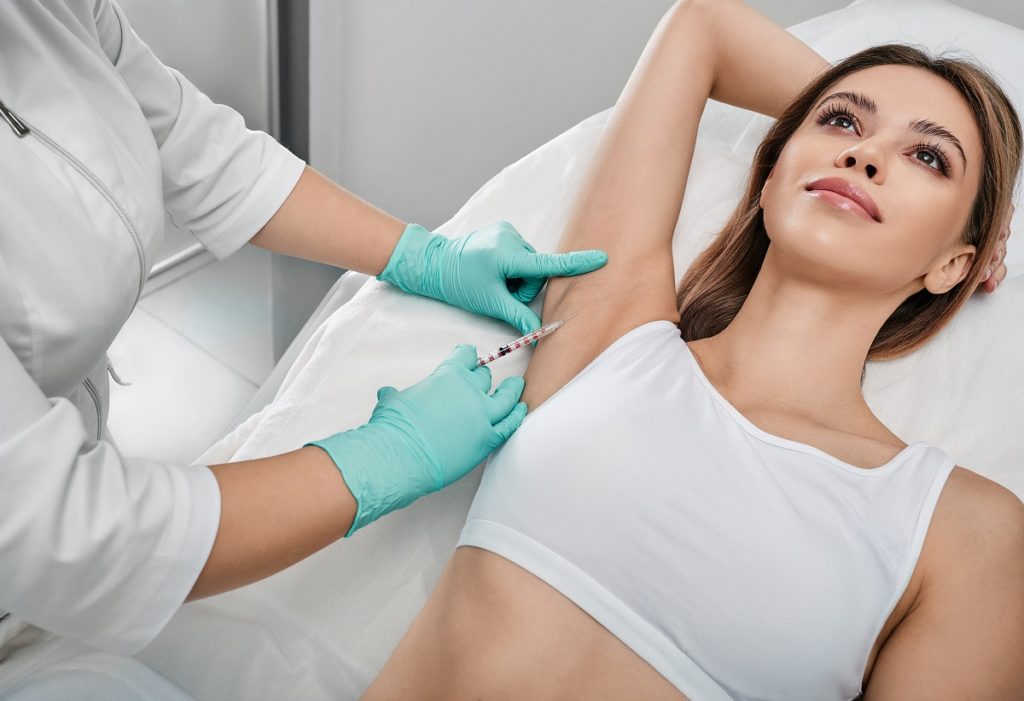Underarm hyperhidrosis treatment. Armpit injections to prevent excessive sweating for female patient with beautician at cosmetology | Revive MD Inc in Barrie, ON