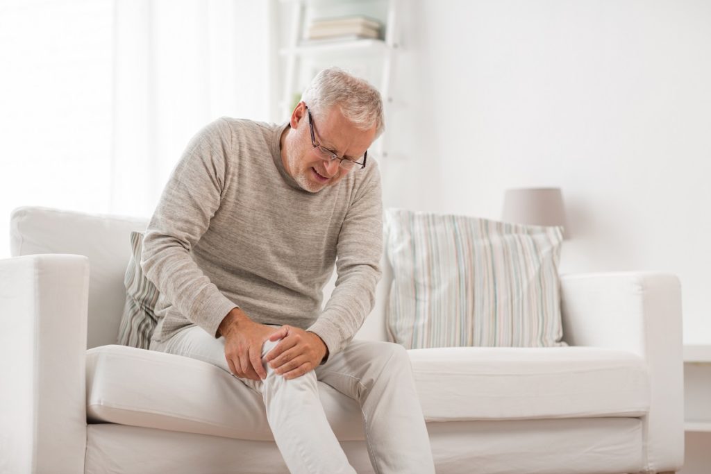 Senior man suffering from knee ache at home. people, health care and problem concept - unhappy senior man suffering from knee ache at home | Revive MD Inc in Barrie, ON