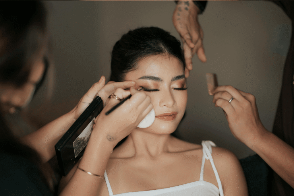 A woman beams with confidence as sunlight kisses her dewy skin. Her natural glam look, featuring a light foundation and subtle highlight, enhances her features without overpowering them—perfect for brunch, headshots, or everyday confidence.